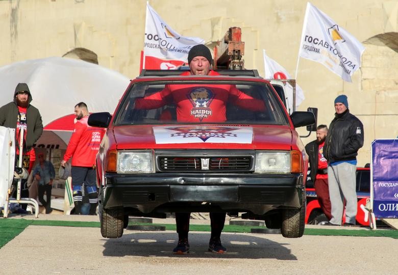 An athlete carries a body of a car during a strongmen contest "People are stronger than machines" in Sevastopol, Crimea, November 21. REUTERS/Alexey Pavlishak
